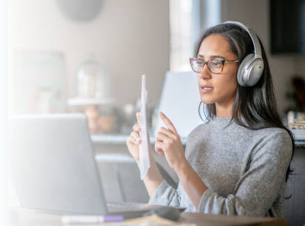 Person talking in a virtual meeting wearing headphones